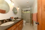The shared bathroom is spacious with double vanities and a walk-in shower
